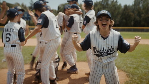 Happy children playing little league baseball and celebrating.